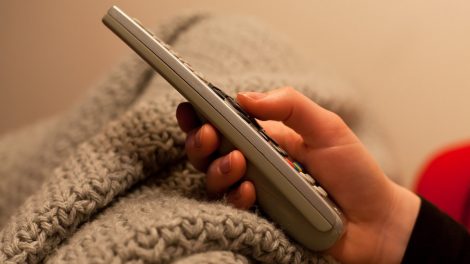 Foto di telecomando in mano a una persona. Licenza CC di Willem van de Kerkhof