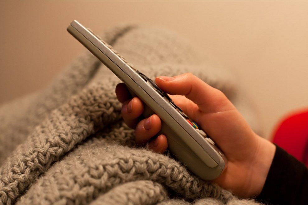 Foto di telecomando in mano a una persona. Licenza CC di Willem van de Kerkhof