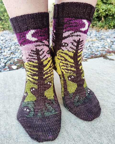 Calzini a maglia con piccole figure nere che si nascondono dietro gli alberi. Modello di Jennifer Beaulieu