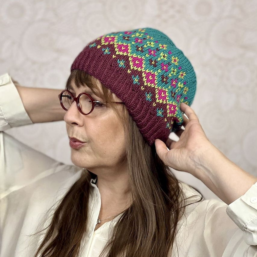 La designer di maglia Valentina Cosciani indossa una delle sue creazioni: un cappellino a maglia realizzato con tecnica stranded a più colori.